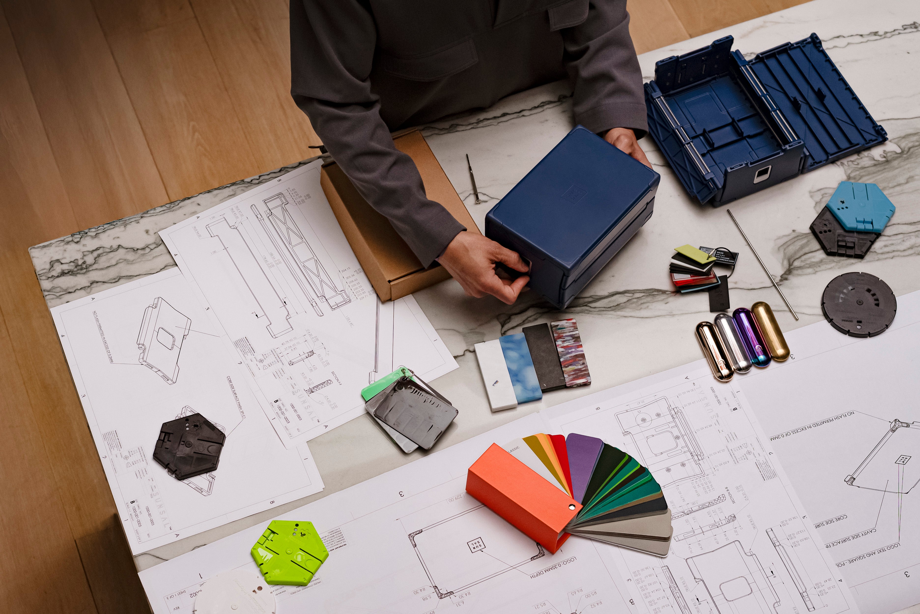 Overhead view of the Sunsal yoga block design process with schematics, prototypes, and material samples, showcasing the thoughtfulness behind its creation