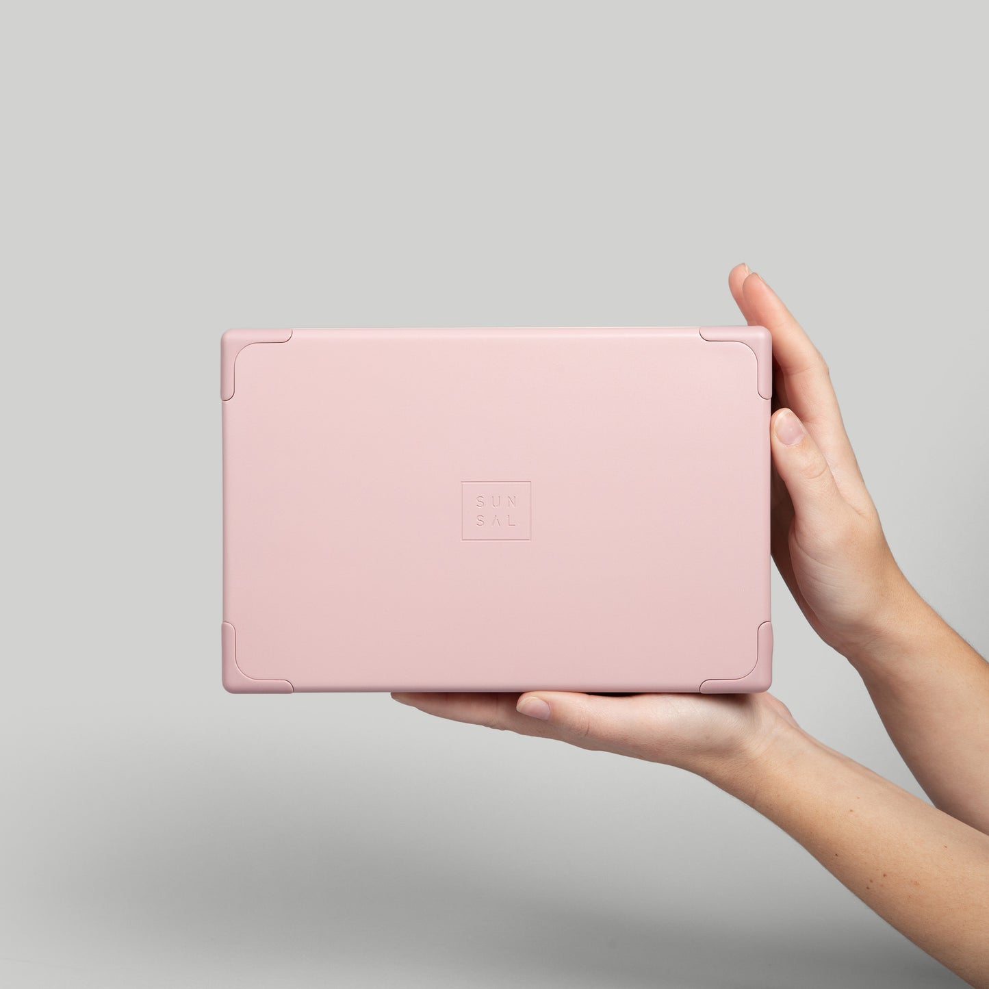 Sunsal yoga block in Rosewood held in hands, emphasizing its sleek, minimalist design