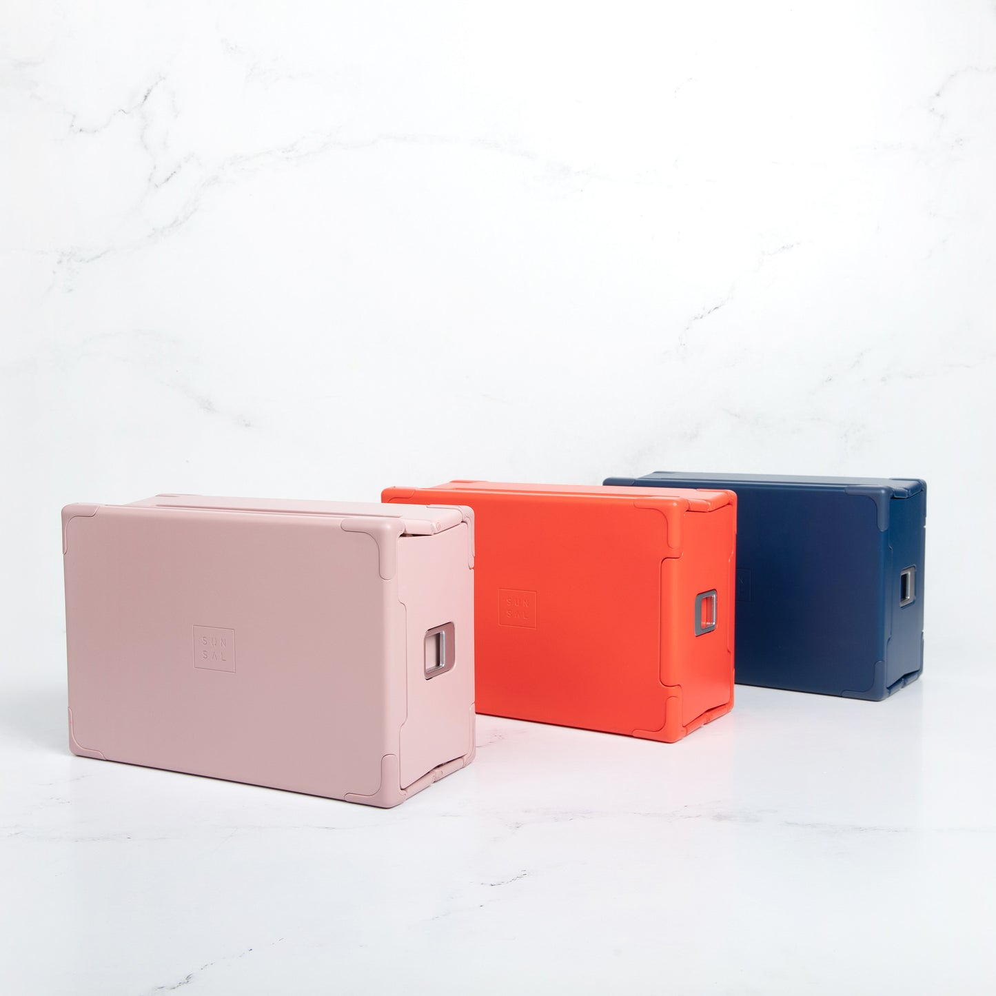 Sunsal yoga blocks in Rosewood, Coral, and Navy displayed upright, highlighting their sleek and modern design