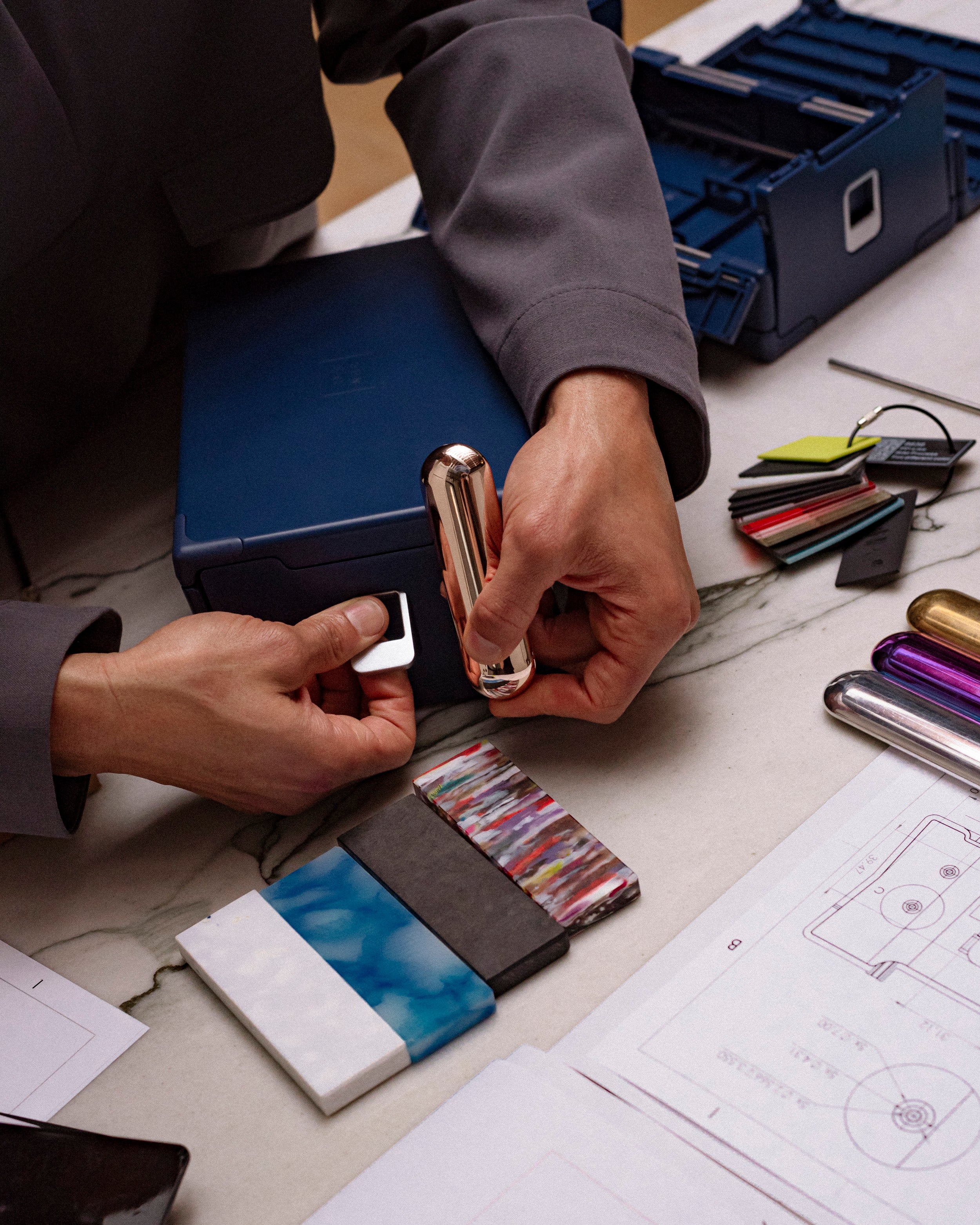 Close-up of hands assembling the Sunsal yoga block in Navy with material samples and tools, highlighting craftsmanship and attention to detail