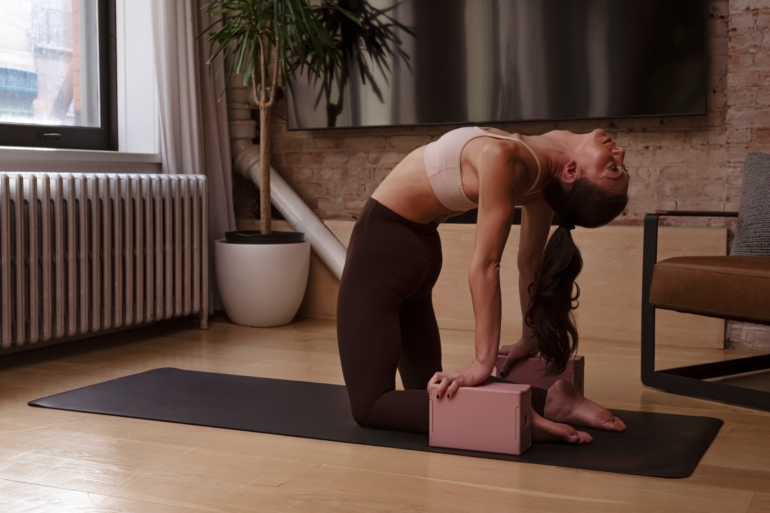 Yogi in camel pose using Sunsal yoga blocks in Rosewood, showcasing stability and support during an advanced backbend