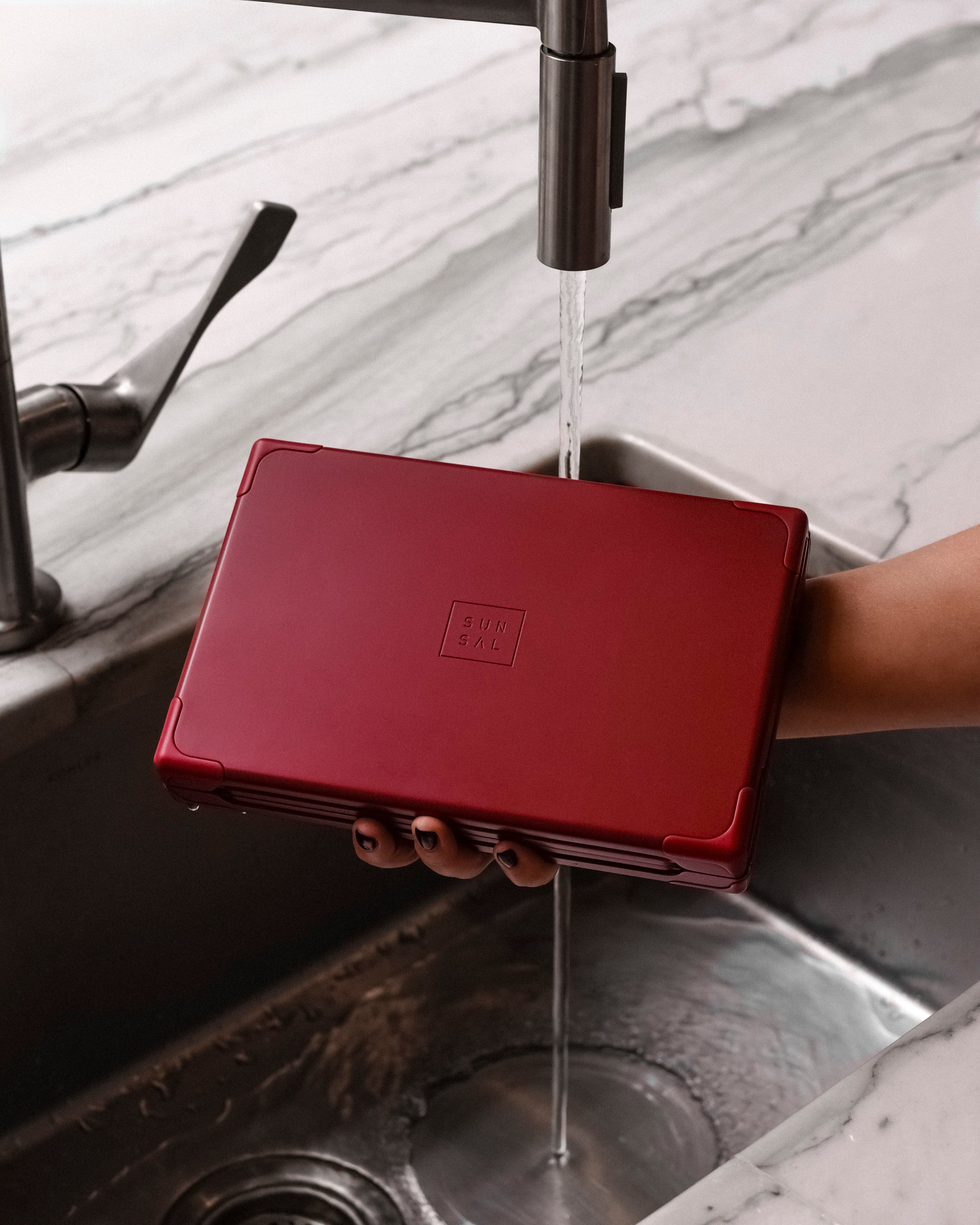 SUNSAL yoga block under running water in a sink, showcasing easy-to-clean materials