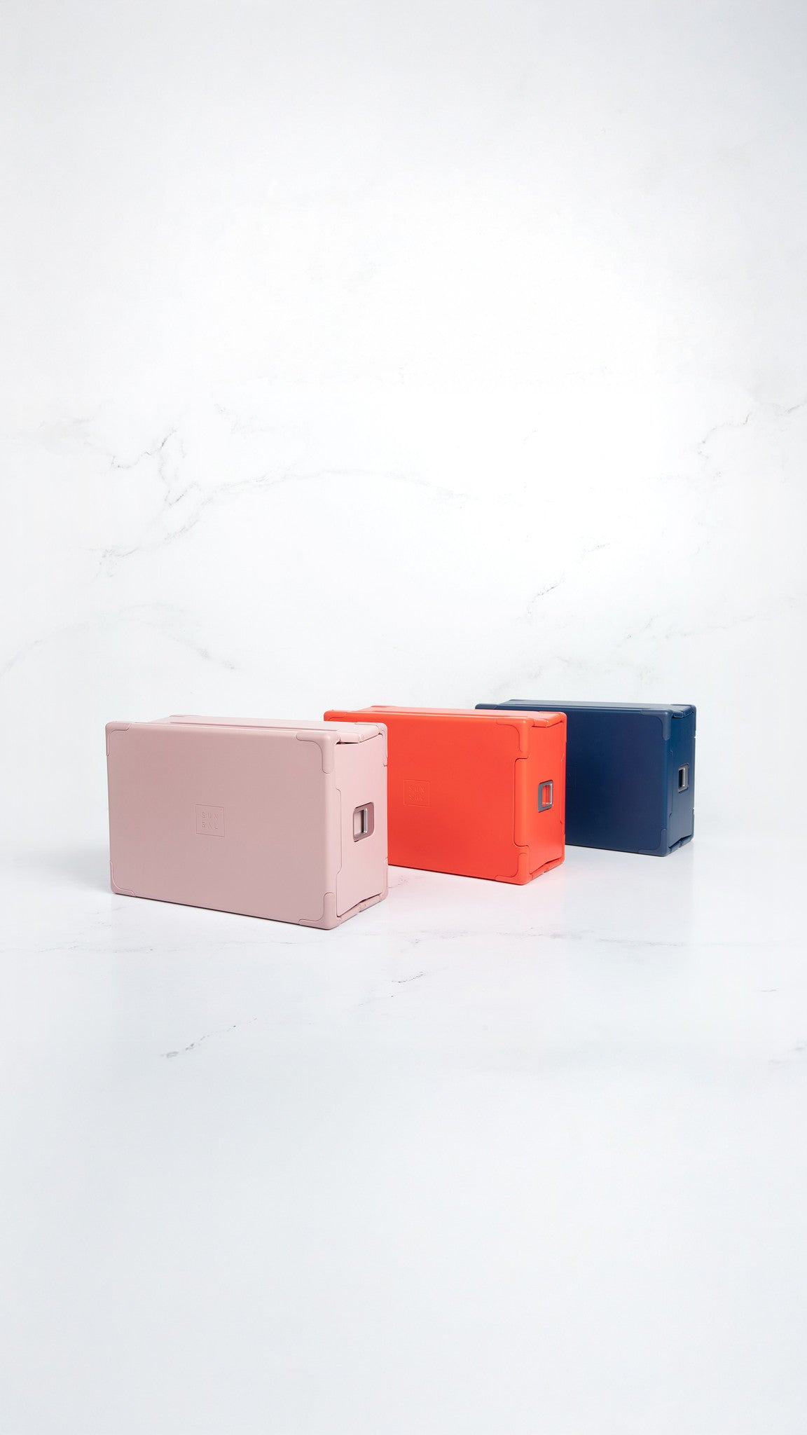 Sunsal yoga blocks in Rosewood, Coral, and Navy displayed upright on a clean white background, showcasing their modern and minimalist design